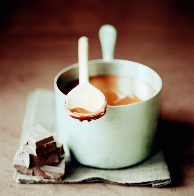 Melted couverture in pan, block of chocolate in front