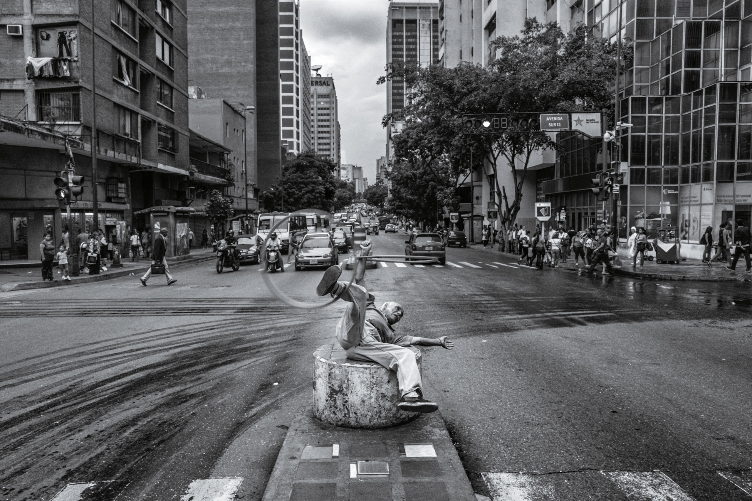 CARACAS, VENEZUELA - JUNE 2016: A street performer works for spare change on a traffic officer's pedestal in Caracas in June