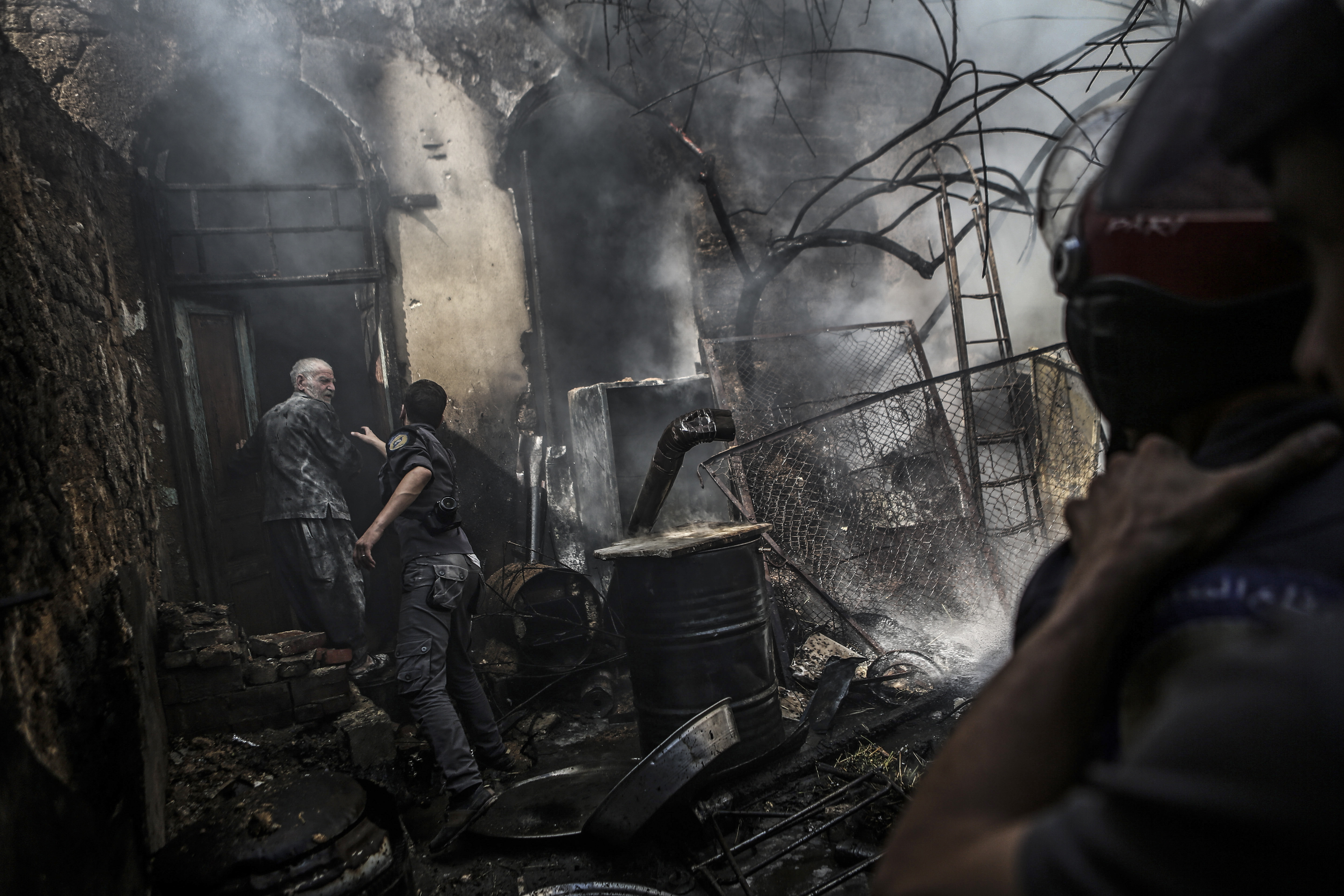 Firefighters extinguish flames following an airstrike by forces loyal to the Syrian government in the rebel-held area of Douma, on the outskirts of Damascus, on Sept. 11, 2016.