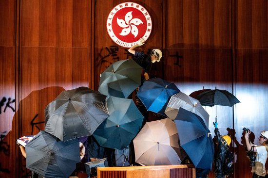 A protester defaces the Hong Kong emblem after protesters broke into the government headquarters on July 1, 2019.