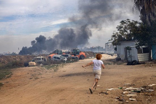 An Israeli runs to a shelter in Ashkelon on Oct. 7