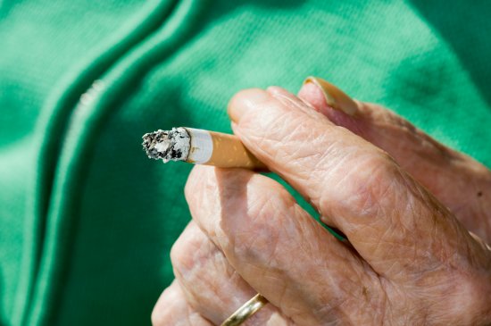 Elderly Hand Holding Cigarette Butt