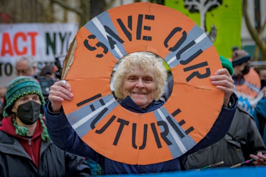 Participant seen holding a sign at the protest. Climate