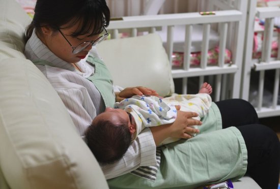 A social worker cares for a baby at the Jusarang Community Church in southern Seoul on May 24, 2017.