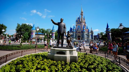 Park guests walk near the statue of Walt Disney and Mickey Mouse in the Magic Kingdom at Walt Disney World on July 14, 2023.