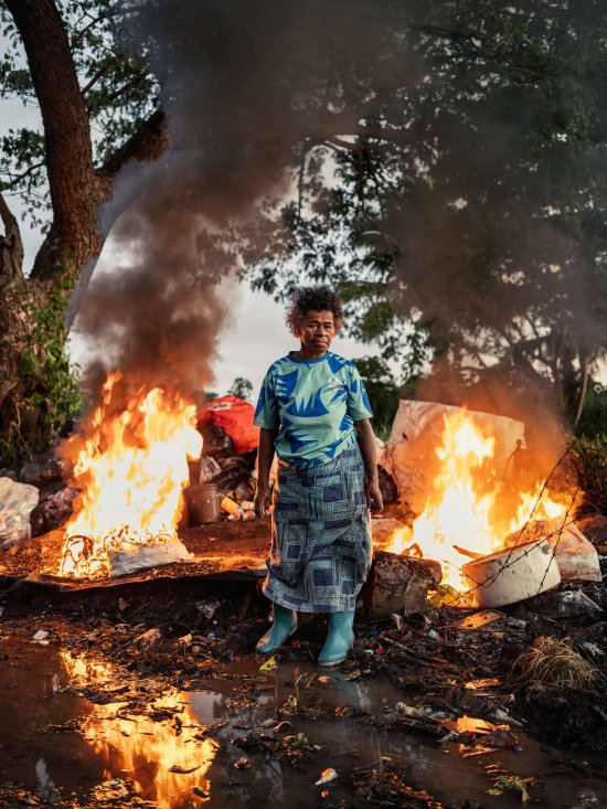 Asinate Lewabeka, a woman who makes an income washing and sorting cans, plastic bottles and other materials for recycling, burns trash near her home in Vunato settlement, Lautoka, on Viti Levu, Fiji on May 9, 2024. Photo by Adam Ferguson for TIME