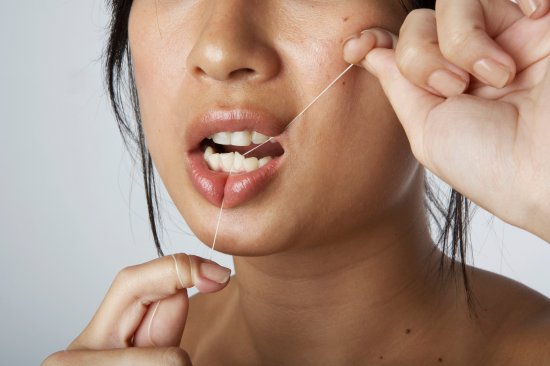 Woman flossing teeth