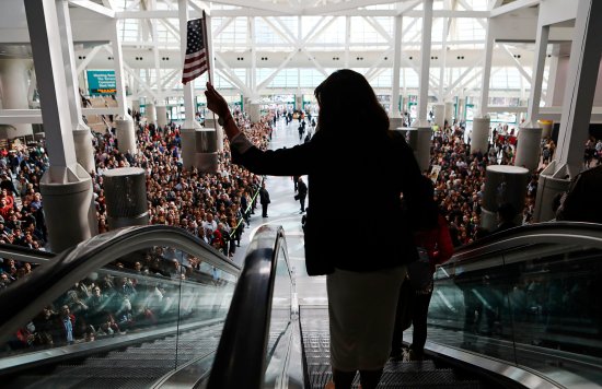 A new U.S. citizen, leaving a 2018 mass naturalization ceremony in L.A., waves the flag