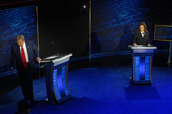 Former President and Republican presidential candidate Donald Trump walks away during a commercial break as Vice President and Democratic presidential candidate Kamala Harris take notes during a presidential debate at the National Constitution Center in Philadelphia, on Sept. 10, 2024.